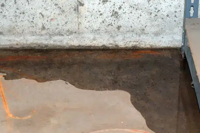 Image of a concrete slab with a pool of water on its surface, illustrating the need for effective waterproofing to prevent water penetration and protect the structural integrity of the concrete.